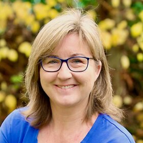 Lächelnde Akademie-Dozentin, die in der Natur steht