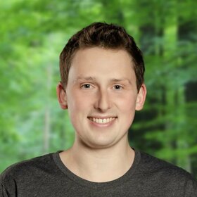 Stehender Akademie-Dozent, der seine Hände in den Hosentaschen hat
