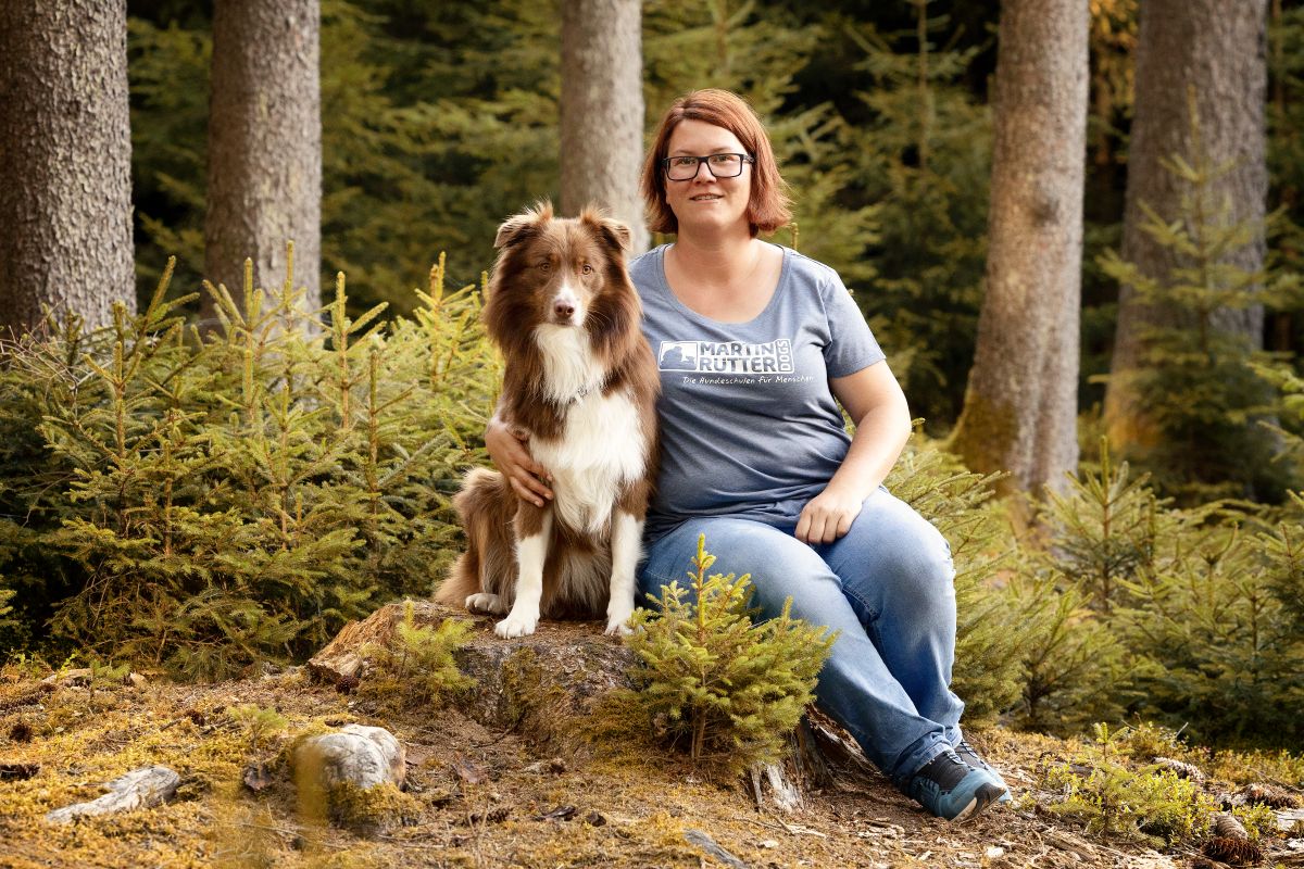 Martin Rütter Hundetrainerin Stefanie Liepert mit ihrem Australien Shepherd im Wald