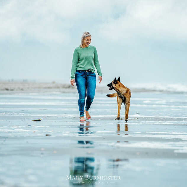 Frau mit Hund am Strand