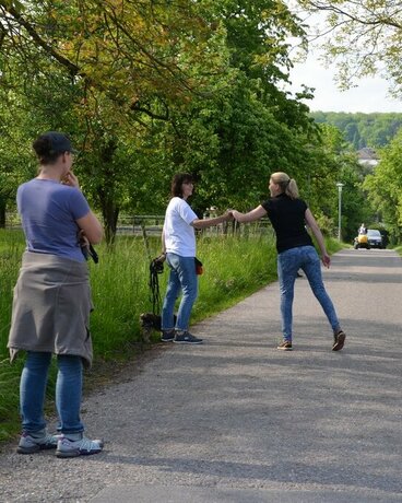 Halter üben die Begrüßungssituation mit anderen Haltern, während Hunde warten müssen.