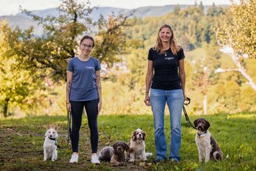 Claudia und Tanja stehen mit ihren 5 Hunden auf der Wiese