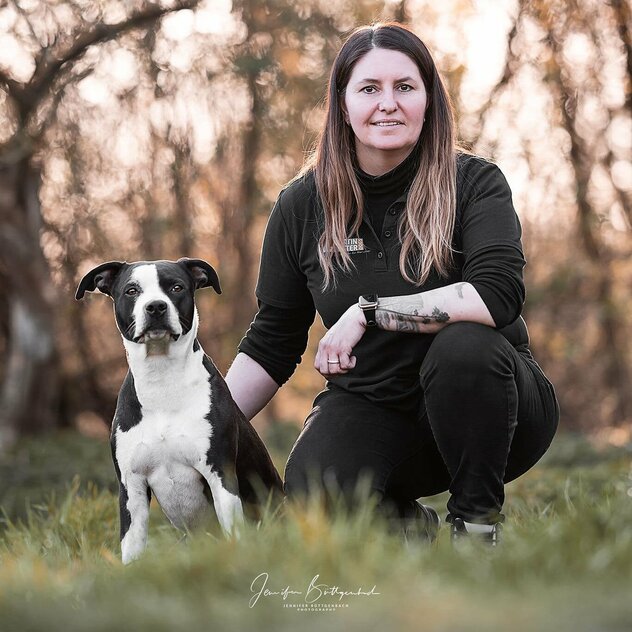 Yvonne Theißen auf einer Wiese mit Hund Kaira