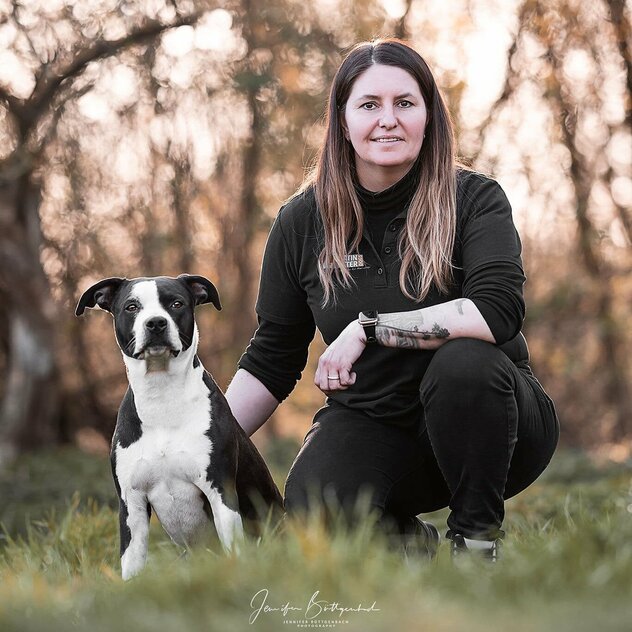 Yvonne Theißen auf einer Wiese mit Hund Kaira