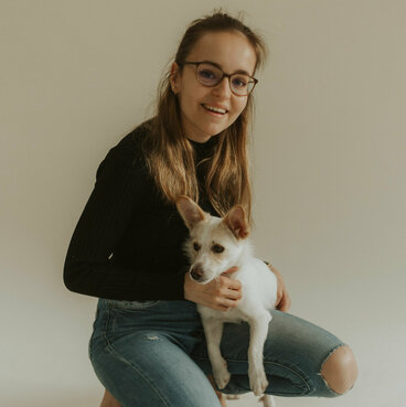 Tanja kniet mit dem Hund auf dem schoss