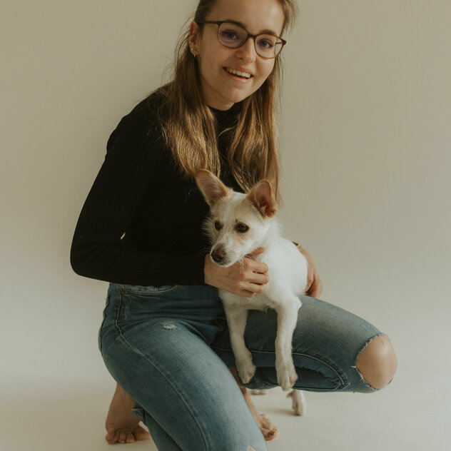 Tanja kniet mit dem Hund auf dem schoss