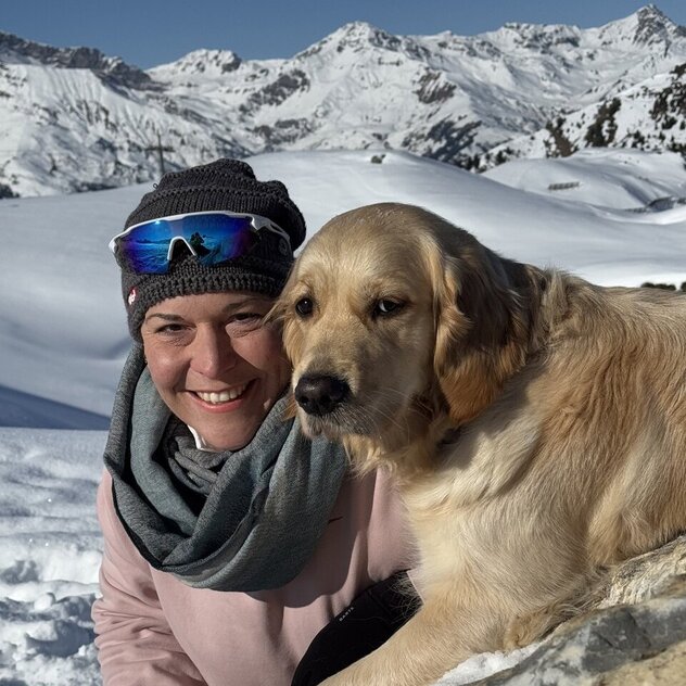 Hundetrainerin mit Hund in den Bergen bei Schnee